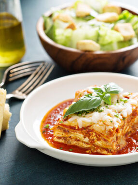 lasagne cut and served in white plate with sauce featured image